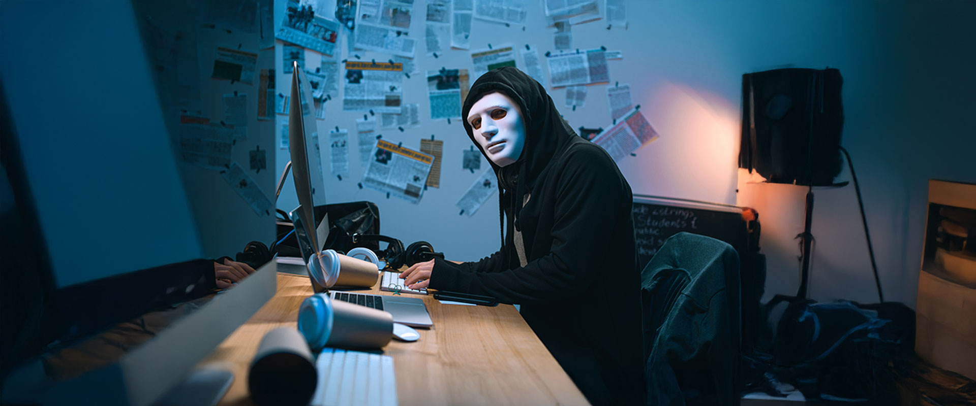 How To avoid Consequences of Ransomware Attack - hacker sitting in front of the computer looking at the camera