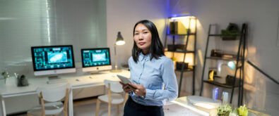 Data Storage Woman Administrator standing in a room with Open-E JovianDSS GUI displayed on desktop