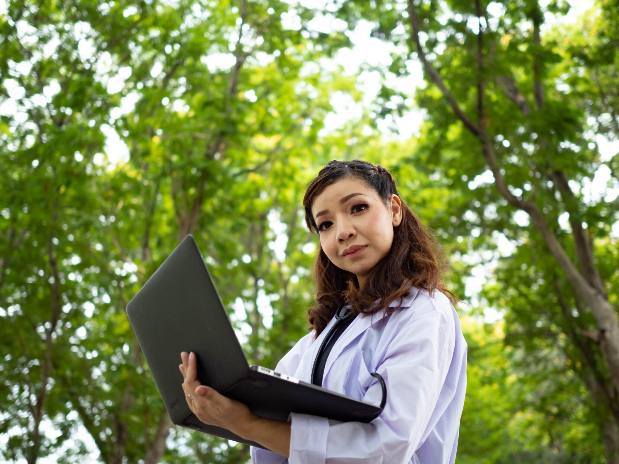 Girl with a laptop working in the garden surrounded by trees | Open-E JovianDSS