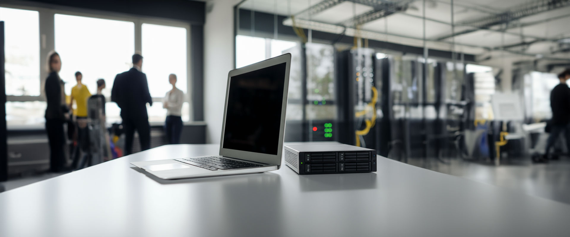 laptop on a board with an IT team in the background discussing the differences between NAS and SAN data storage system